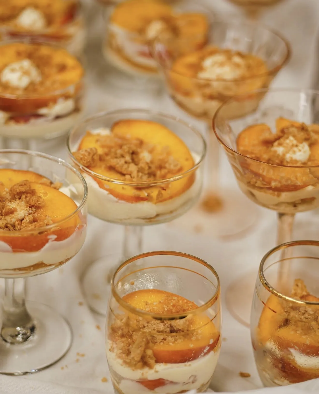 Two lemon Greek yogurt parfaits with roasted peaches and pistachio-almond crumble